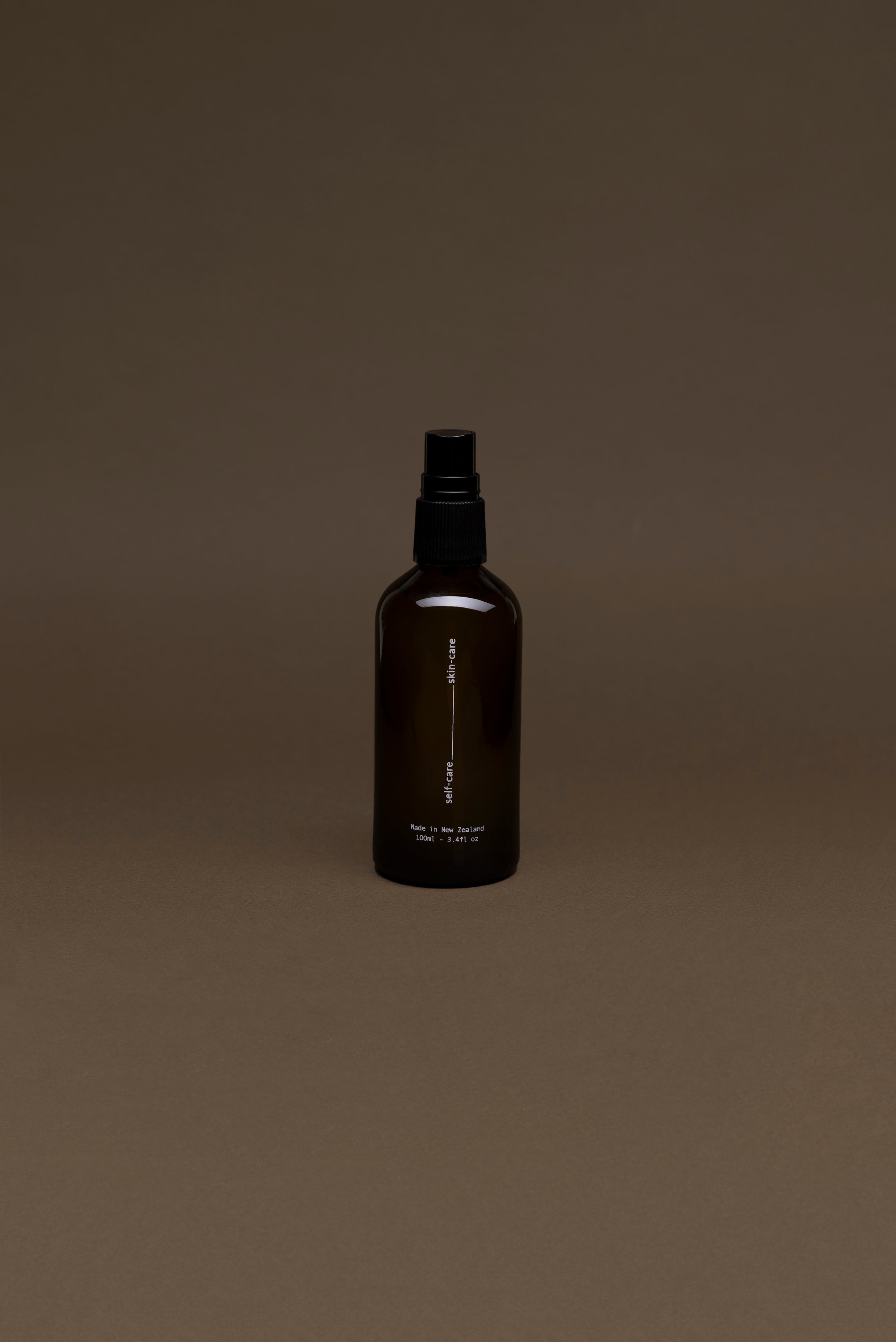 Rear view of Tahi Skincare Toning Face Mist bottle with Lavender and Koromiko, showing amber packaging and spray top from a distance.