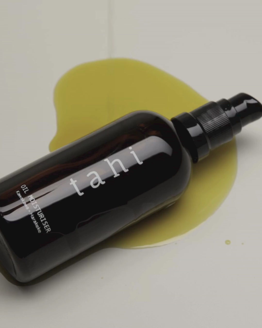 Tahi brand oil moisturiser bottle with product dripping around the bottle