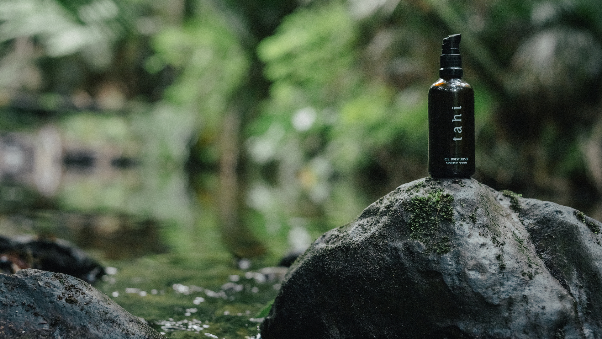 Tahi oil moisturiser on a rock by the water