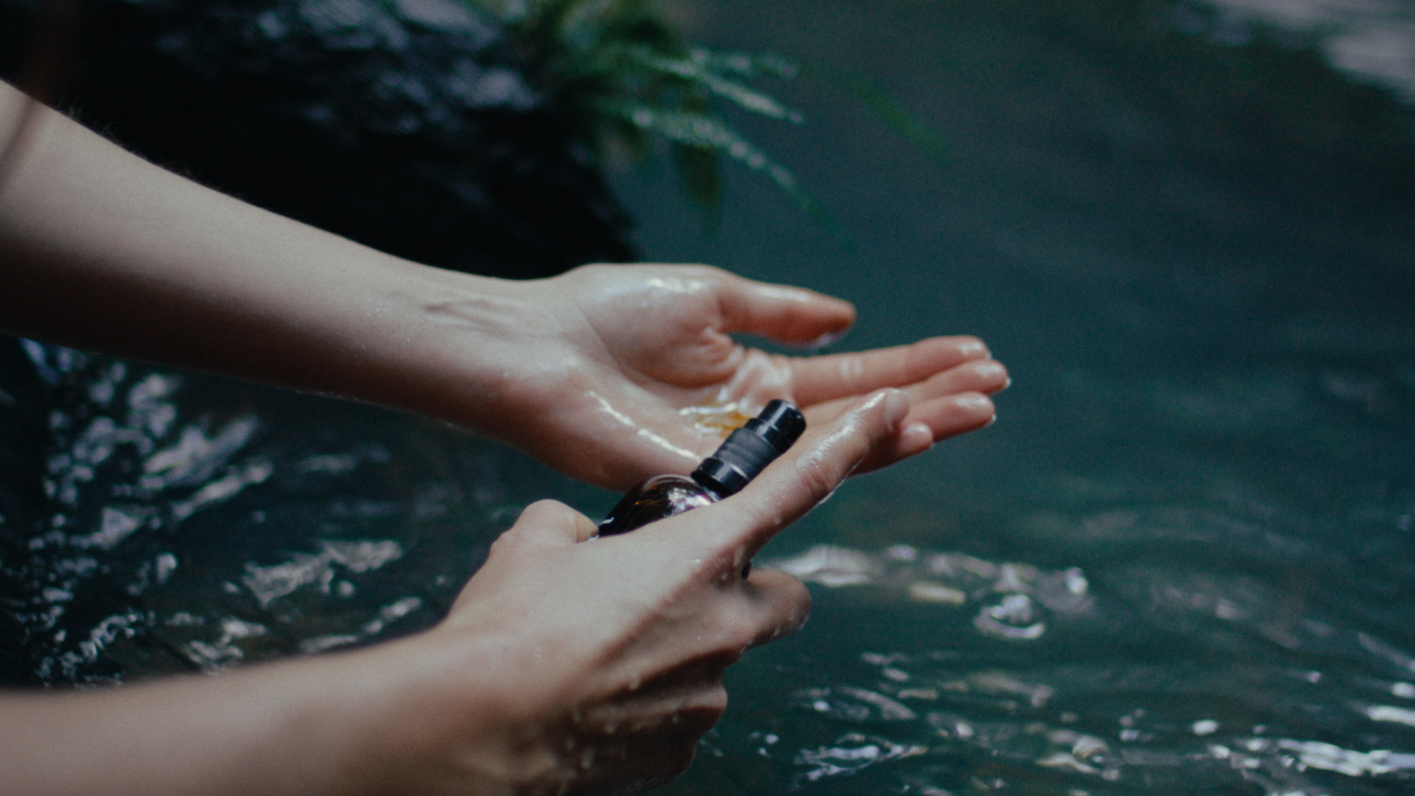 tahi product being pumped onto hands over natural water